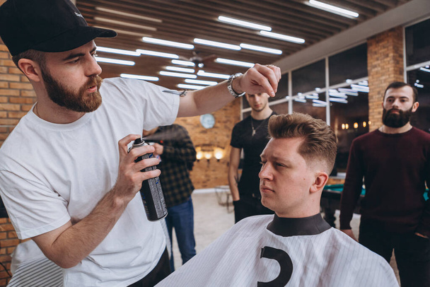 27.02.2020 Odessa, Ukraine: Barbers learn and improve their skills at a professional barber. Hipster man client visiting haidresser and hairstylist in barber shop - Foto, imagen