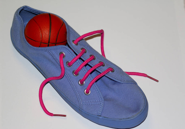 Chaussure de sport bleu clair avec une balle à l'intérieur isolé sur un fond blanc, concept de retour à l'école et à la maternelle - Photo, image