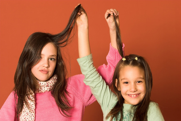 Two pretty girls touching hair - Foto, afbeelding