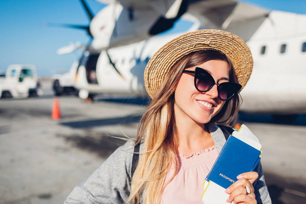 Женщина-путешественница садится в самолет с билетами на паспорт. Счастливый пассажир с рюкзаком готов к полету. Летние каникулы. Возобновление рейсов - Фото, изображение