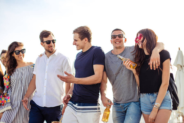 holidays, vacation. group of friends having fun on beach, walking, drink beer, smiling and hugging - Φωτογραφία, εικόνα