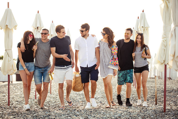 holidays, vacation. group of friends having fun on beach, walking, drink beer, smiling and hugging - Foto, Imagem
