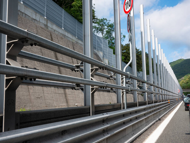 Barandilla de protección y serie de postes metálicos utilizados para soportar las barreras de absorción de sonido necesarias para aislar el ruido de la carretera
 - Foto, imagen