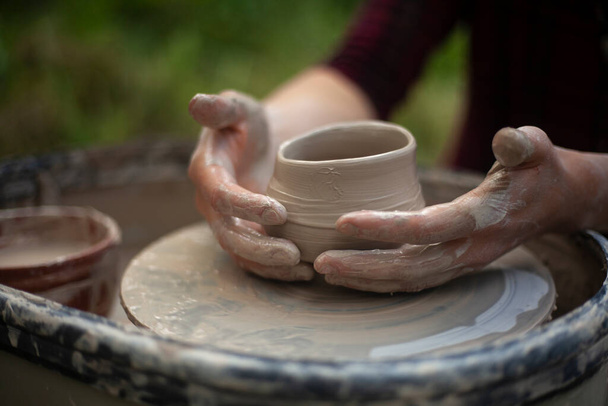 Potter at work. Hands sculpt clay. Creation of dishes. - Photo, Image
