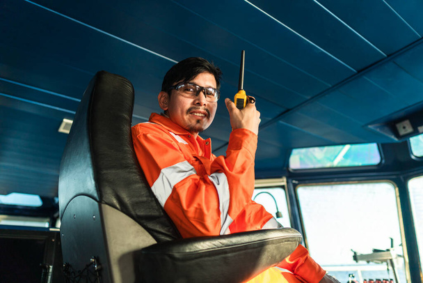 Filipiński oficer pokładowy na mostku statku lub statku. Mówi w radiu GMDSS VHF - Zdjęcie, obraz