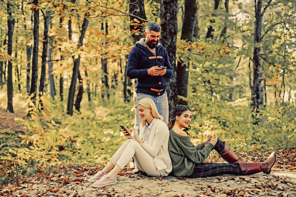Young friends with autumnal mood. Autumn and leaf fall Dreams. Enjoying nice weekend students together. People on Autumn background. Autumn travels. - Zdjęcie, obraz