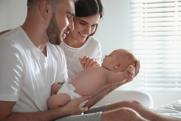 Happy couple with their newborn baby at home - Foto, afbeelding