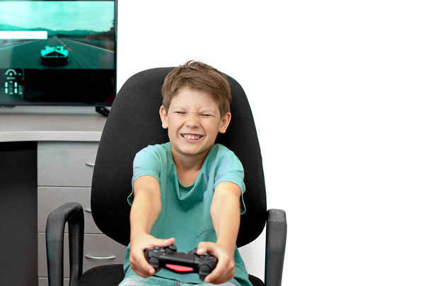 Teini-ikäinen poika verkossa pelaa tietokonepeliä kuulokkeilla ja joystick, pelikonsoli. - Valokuva, kuva