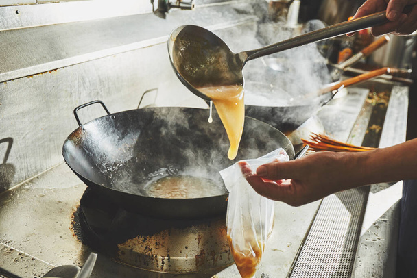 Chef stir fry cooking in kitchen - Foto, Bild
