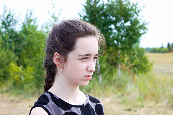 Portret van een tienermeisje tegen de achtergrond van de natuur, dat bij zonnig weer kraakt. Sluiten.. - Foto, afbeelding