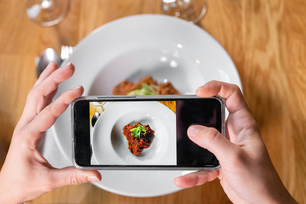 Man hand with smartphone photographing food at restaurant or cafe - Foto, immagini