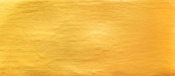 Gold wall texture background. Yellow shiny gold paint on concrete wall surface, vibrant golden luxury wallpaper, horizontal - Photo, Image