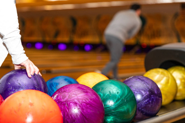 Hand picking up bowling ball at bowling alley. - Photo, Image