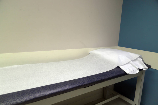 Медицинский стол для осмотра пациентов в кабинете врача - Фото, изображение
