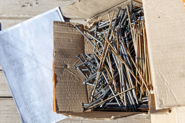 In the box are prepared for the construction of long nails and screws. Abakan, Russia-April 6, 2020 - Photo, Image