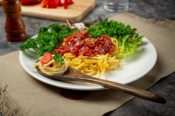 Pyszne spaghetti serwowane z pięknymi składnikami. - Zdjęcie, obraz