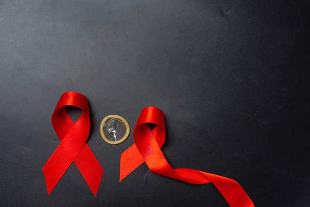 Красная лента знаний и презервативы осведомленность о ВИЧ, Всемирный день борьбы со СПИДом и Всемирный день сексуального здоровья. - Фото, изображение