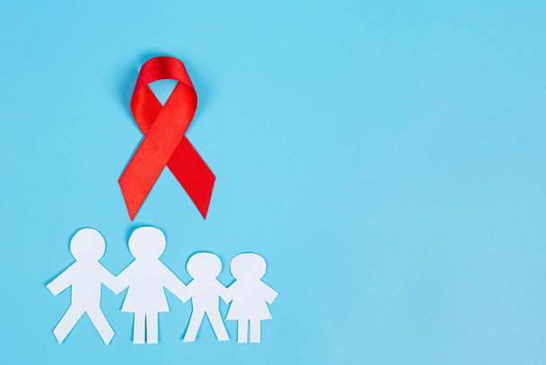Red knowledge ribbon and family cut paper, HIV awareness, World AIDS Day and World Sexual Health Day. - Foto, Imagen