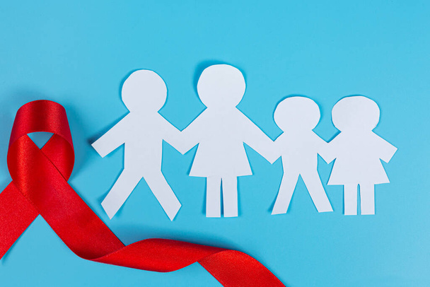 Red knowledge ribbon and family cut paper, HIV awareness, World AIDS Day and World Sexual Health Day. - Fotoğraf, Görsel