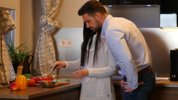 A young couple cooking together in the kitchen at home. - Imágenes, Vídeo