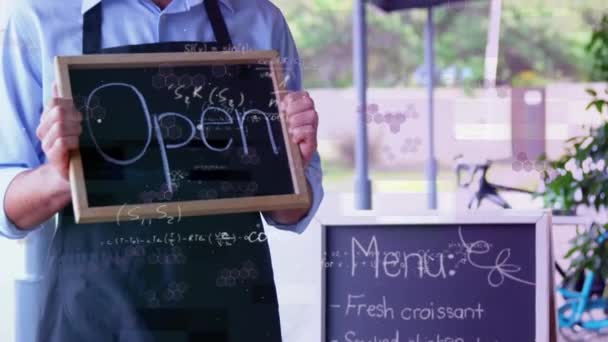 Animation of mathematical equations floating over happy Caucasian male chef holding Open sign in restaurant. Small business reopening during Covid-19 coronavirus pandemic concept. - Séquence, vidéo