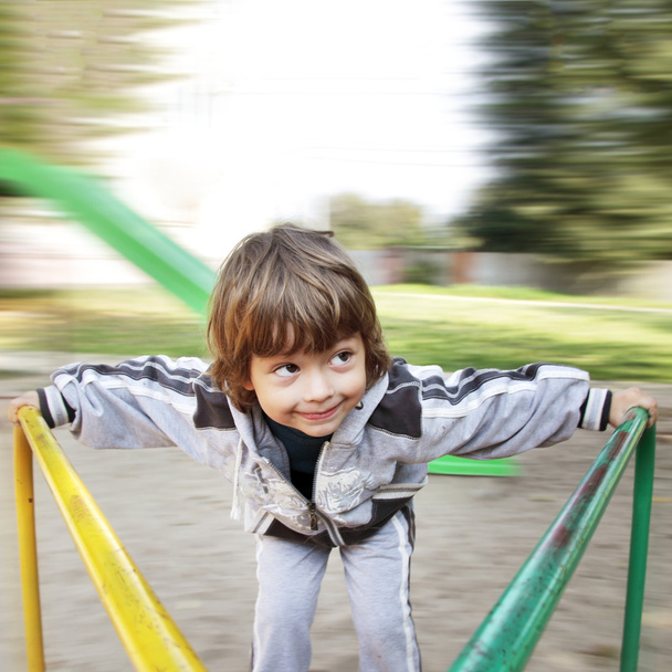 happy boy on carousel outdoors - Фото, изображение