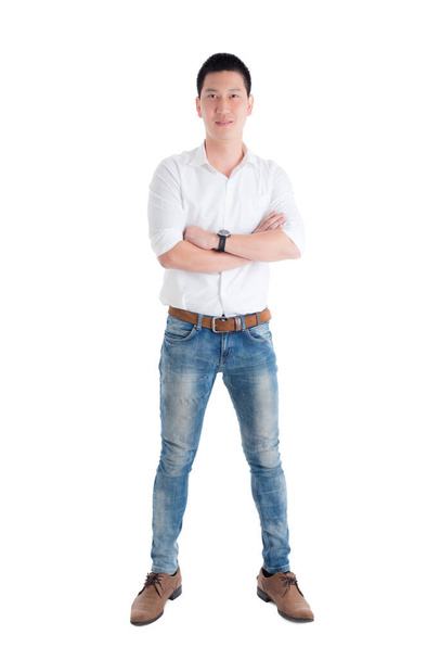 Pleine longueur de bel homme asiatique en chemise blanche debout et sourit sur fond blanc. - Photo, image