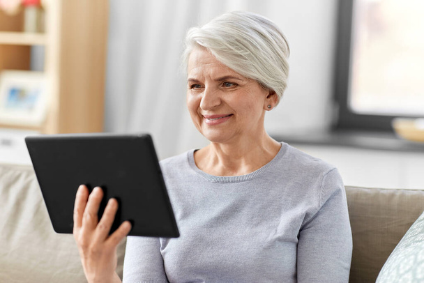 happy senior woman with tablet pc at home - Foto, immagini