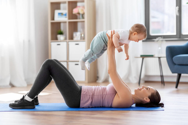 happy mother with little baby exercising at home - Foto, immagini
