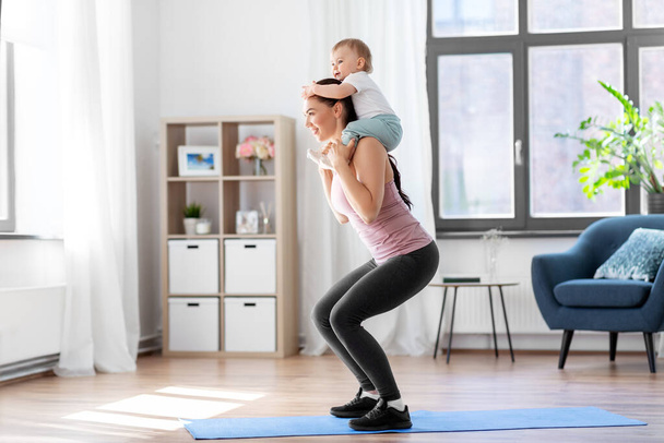 happy mother with little baby exercising at home - Фото, зображення