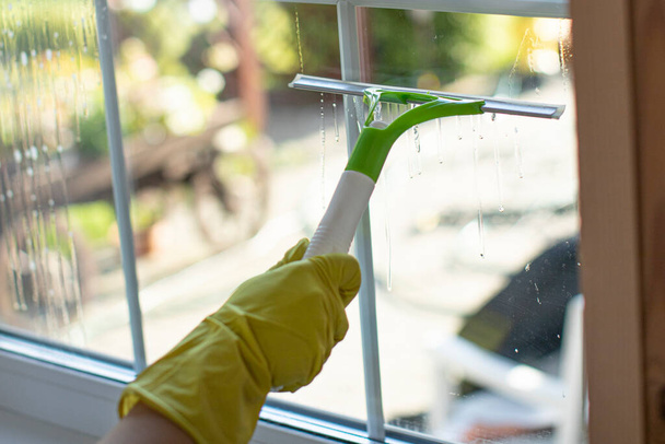 Zavřít osobu v gumové rukavice utěrky, tře prach stěračem pro čištění oken - Fotografie, Obrázek