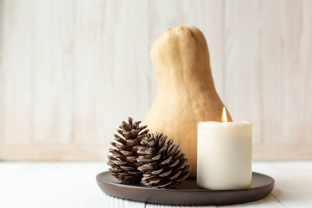 Autumn or winter composition with pumpkin, candle and pine cones. Scandinavian style Hygge Soft focus - Image - Foto, afbeelding
