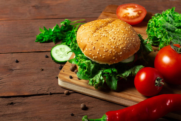 Μαγείρεμα burger σε σκούρο ξύλινο φόντο. Δίαιτα, όχι κρέας. - Φωτογραφία, εικόνα
