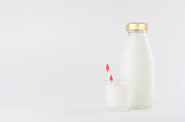 White milk, dairy product in glass bottle  mock up with glass, red straped straw in soft light white background. - Φωτογραφία, εικόνα