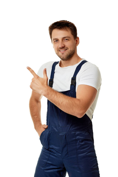 repairman in overalls pointing at copy space. - Φωτογραφία, εικόνα