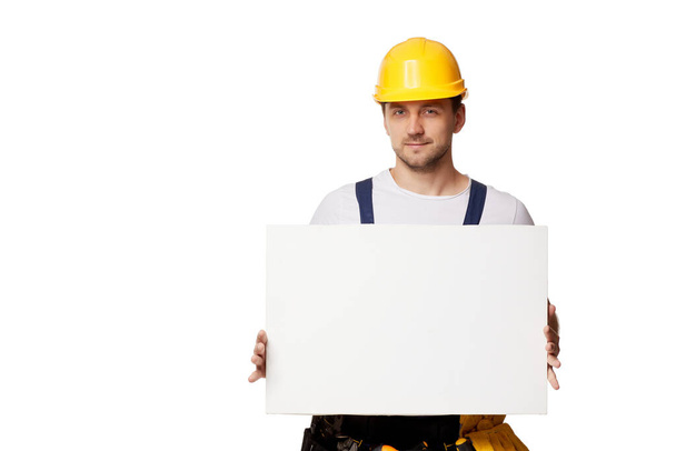 repairman in uniform holding empty blank board. - Valokuva, kuva