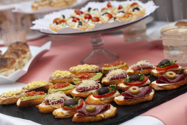 brutlets on event table with toasted bread ham cheese olives guacamole - Фото, изображение