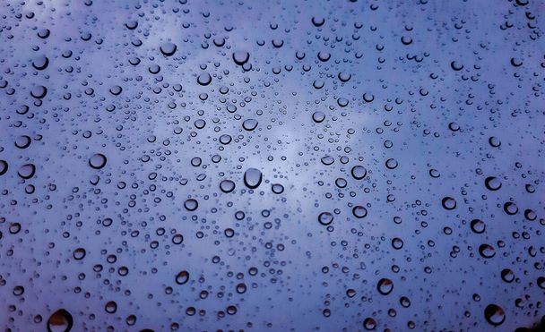 Hermosa fotografía de la gota de agua sobre la ventana. Vista panorámica interior de la ciudad después de la lluvia
. - Foto, imagen