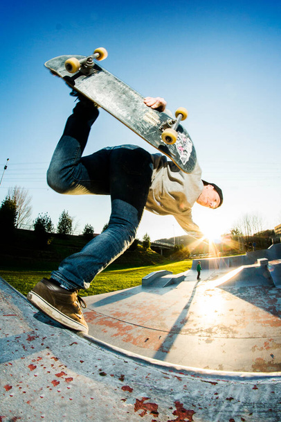 Skateboarder faire un tour dans le skatepark avec un beau coucher de soleil - Photo, image