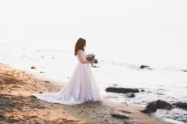 Romantic beautiful bride in white dress posing on the background sea - Photo, Image