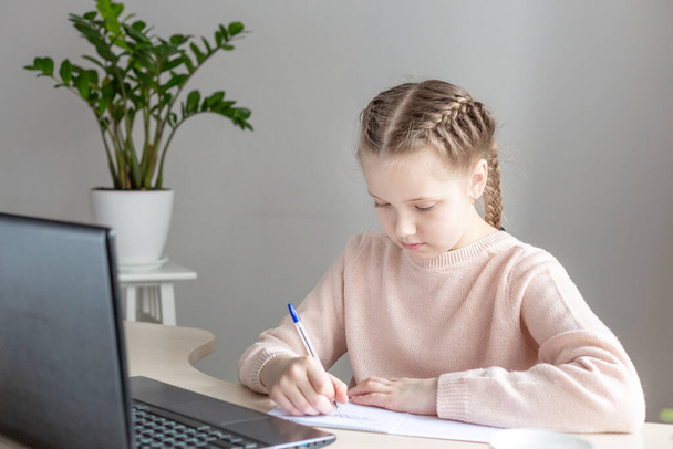 School girl sitting at desk and doing homework. Education Back to school - Image - Fotoğraf, Görsel