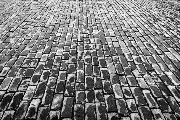 雨の後にぬれた石の道を舗装上のビュー。花崗岩の質感の古い舗装。街の石畳の歩道。デザインの要約. - 写真・画像