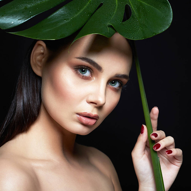 beautiful girl under palm umbrella. Beautiful young woman with Make-up. Beauty Portrait. Natural cosmetics - Photo, Image