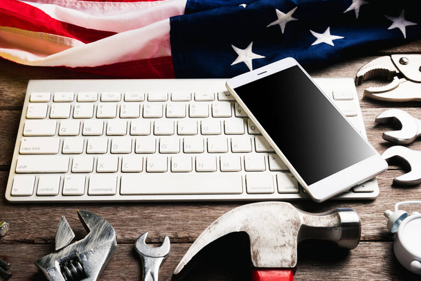Happy USA Labor day, different kind wrenches with American flag and smartphone blank screen on keyboard. First Monday in September creation of labor movement and dedicated to social of American worker - Photo, Image