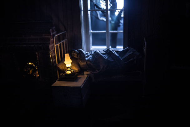 Man comfortabel slapen in zijn bed 's nachts. Een realistische poppenhuis slaapkamer met meubilair en raam 's nachts. Selectieve focus - Foto, afbeelding