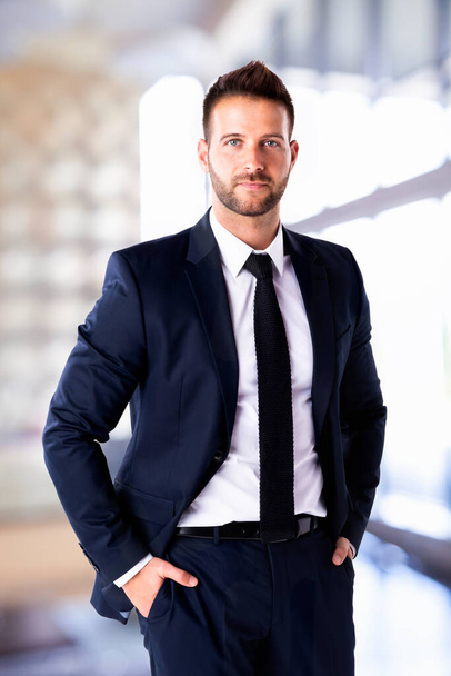 Portrait shot of handsome businessman wearing suit while standing in the office. Copy space. - Foto, Imagem