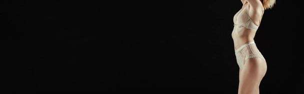 Imagen horizontal de mujer en lencería beige aislada en negro
  - Foto, imagen