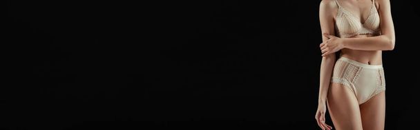 Imagen horizontal de la mujer en ropa interior brazo táctil aislado en negro
  - Foto, imagen