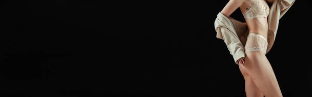 Horizontale Ernte von Frau in Dessous und Hemd steht isoliert auf schwarz mit Kopierraum  - Foto, Bild