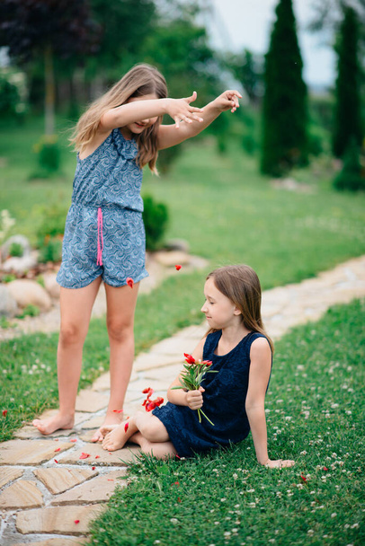 two happy girls in  park with flowers - Valokuva, kuva